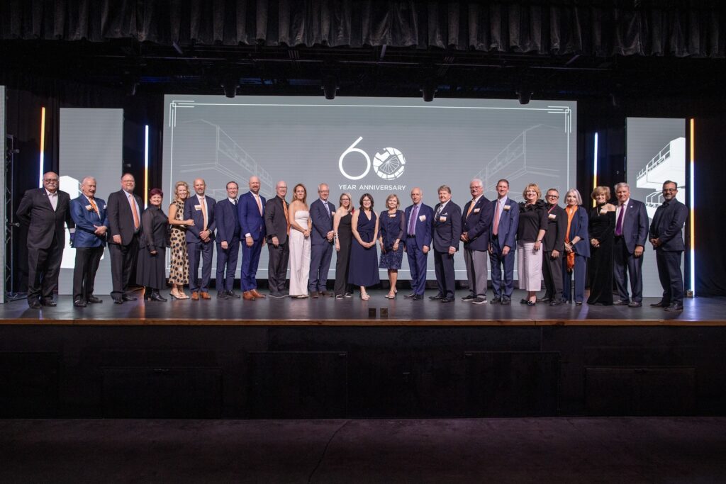 Inaugural inductees of the Siena Society on stage at the college's 60th anniversary gala. 24 individuals pictured.