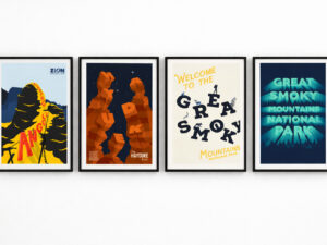 Four framed student-designed national park posters displayed side by side on a white gallery wall, featuring designs for Zion, the Hayduke Trail, and two interpretations of Great Smoky Mountains National Park.