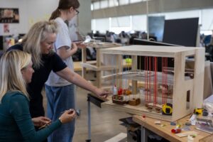Professor Liz Teston examines student model with student