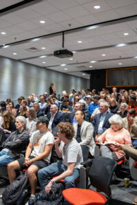 An audience fills seats in an auditorium.