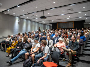 An audience fills seats in an auditorium.